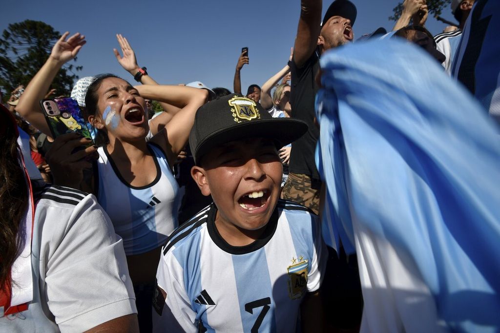 Penggemar Argentina bersorak sorai merayakan gol penalti Lionel Messi yang membuka kemenangan Argentina atas Kroasia, 3-0, ada laga semifinal Piala Dunia Qatar 2022, saat menyaksikan lewat layar lebar di wilayah Palermo, Buenos Aires, Argentina, Selasa (13/12/2022). 