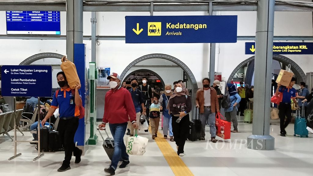 Seorang tukang angkat barang (<i>porter</i>) membawa barang milik penumpang yang baru tiba di Stasiun Pasar Senen, Jakarta Pusat, Kamis (9/3/2023), dari perjalanan luar kota.