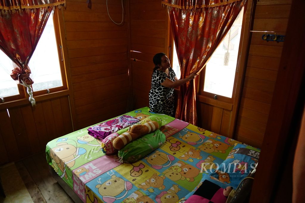Sarce Natari (42) menggulung tirai di rumah penginapan (<i>homestay</i>) miliknya di Desa Pulisan yang masuk area Kawasan Ekonomi Khusus Pariwisata Likupang di Likupang Timur, Minahasa Utara, Sulawesi Utara, pada Kamis (14/9/2023). Pada 2021, Kementerian Pekerjaan Umum dan Perumahan Rakyat menyelesaikan pembangunan 263 <i>homestay</i> di tiga desa yang berada di dalam KEK, yaitu Pulisan, Marinsow, dan Kinunang, dengan dana Rp 44 miliar.