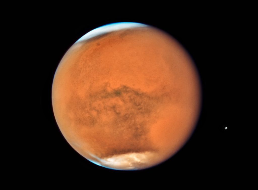 Citra Planet Mars yang diambil pada pertengahan Juli 2018 dengan teleskop luar angkasa Hubble. Citra ini menunjukkan Planet Mars mulai diselimuti badai debu global. Badai debu yang bisa berlangsung beberapa minggu hingga berbulan-bulan itu biasanya terjadi pada paruh kedua tahun Mars atau saat berlangsung musim semi dan musim panas di belahan selatan Mars saat jarak Mars relatif lebih dekat ke Matahari.