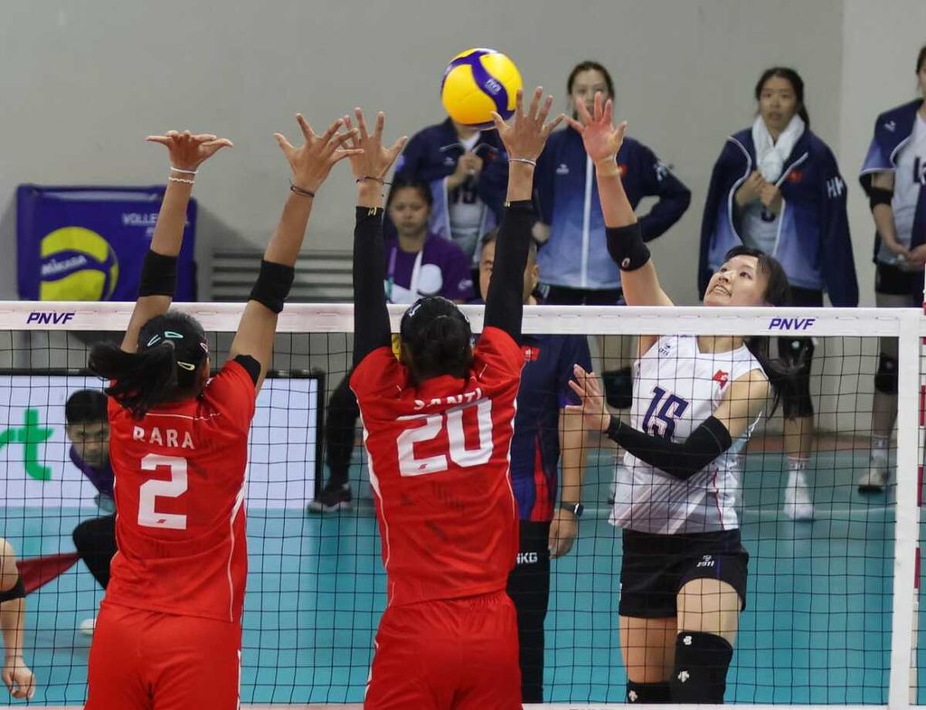 Indonesian women's volleyball players, Maradanti Namira Tegariani (left) and Junaida Santi, block a hit by a Hong Kong player in the AVC Challenge Cup 2024 game at Rizal Memorial Stadium, Manila, Philippines, on Thursday (23/5/2024).