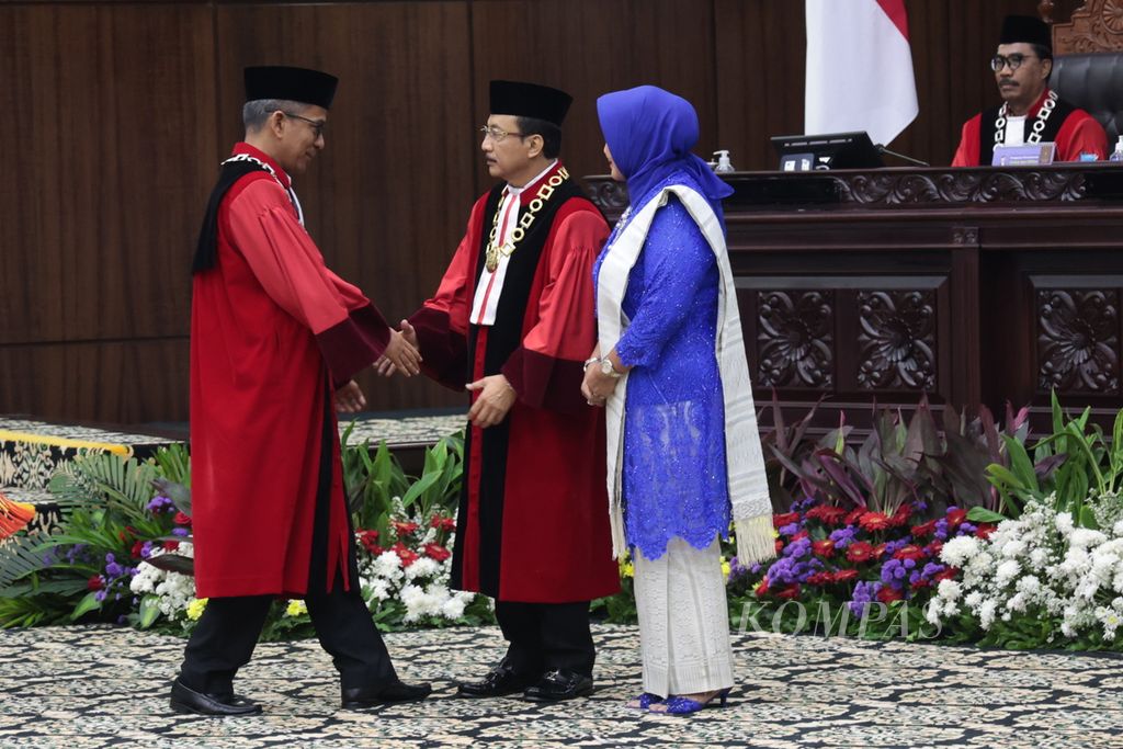 Wakil Ketua Mahkamah Konstitusi Saldi Isra (kiri) memberi selamat kepada Ketua Mahkamah Konstitusi Suhartoyo seusai mengucap sumpah saat dilantik menjadi Ketua Mahkamah Konstitusi (MK) periode 2023-2028 di Gedung MK, Jakarta, Senin (13/11/2023). 