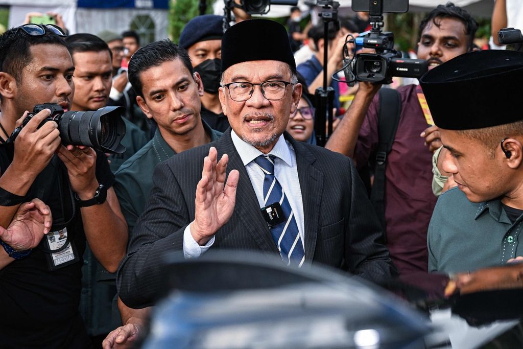 Tokoh oposisi Malaysia, Anwar Ibrahim (tengah), melambaikan tangan ke arah pendukungnya setelah menemui Raja Malaysia di Istana Nasional, Kuala Lumpur, Malaysia, Selasa (22/11/2022).