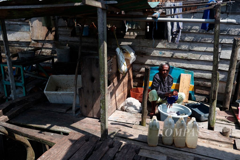 Warga mencuci pakaian di tengah minimnya akses air bersih dengan menampunnya melalui jeriken di Kampung Nelayan Siwalima, Kecamatan Pulau-pulau Aru, Kabupaten Kepulauan Aru, Provinsi Maluku, Kamis (21/9/2023). 