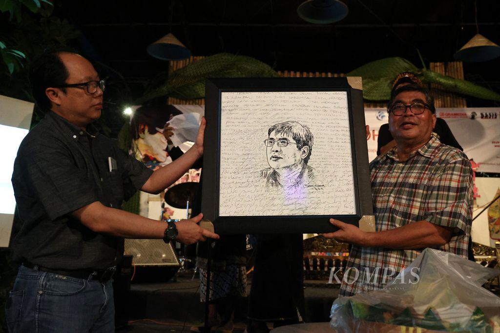 Wartawan senior Sindhunata menerima lukisan dari Pemimpin Redaksi Harian <i>Kompas</i> Sutta Dharmasaputra (kiri) pada acara pembukaan pameran literasi Lelaku Nulis 70 Tahun Sindhunata di Bentara Budaya Yogyakarta, Kotabaru, Yogyakarta, Selasa (17/5/2022). Lukisan tersebut dibuat oleh wartawan <i>Kompas</i> Ilham Khoiri untuk merayakan ulang tahun ke-70 Sindhunata.