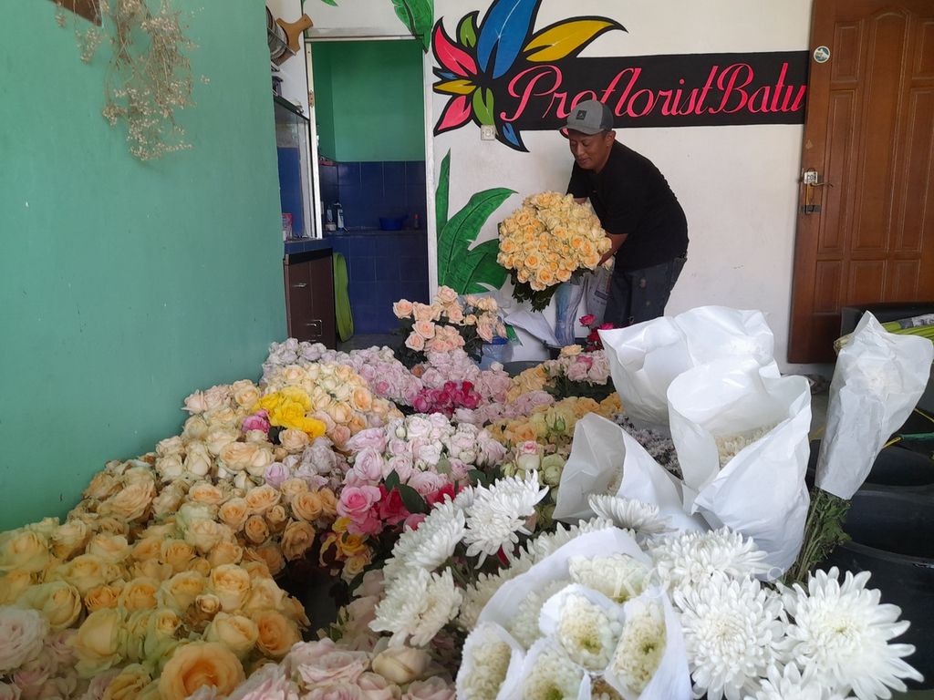Jumadi (33) pemilik "Proflorist Batu" tengah menata aneka bunga potong yang akan dikirim ke konsumen di Dusun Buludendeng, Desa Bulukerto, Kecamatan Bumiaji, Kota Batu, Jawa Timur, Senin (11/4/2022).