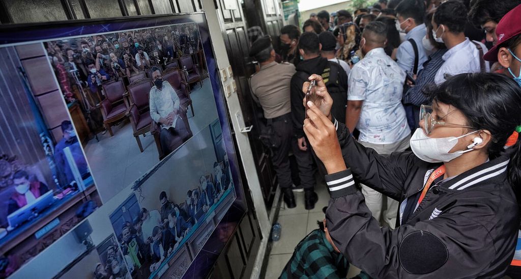 Seorang jurnalis merekam tampilan layar siaran sidang di luar ruangan saat berlangsung sidang vonis terdakwa Ferdy Sambo di Pengadilan Negeri Jakarta Selatan, Jakarta, Senin (13/2/2023). Ferdy Sambo divonis pidana hukuman mati atas pembunuhan terhadap Brigadir Yosua Hutabarat. 