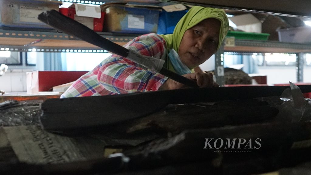 Arkeolog dari Badan Riset dan Inovasi Nasional (BRIN) Sumatera Selatan Retno Purwanti menunjukan potongan perahu yang ada di ruang artefak Kantor BRIN Sumsel, Kamis (14/7/2022). Potongan kayu yang diduga berasal pada masa Kedatuan Sriwijaya ini ini ditemukan di Kabupaten Musi Banyuasin pada tahun 2014, Sumatera Selatan. Ini menunjukan bahwa perahu menjadi alat transportasi bagi masyarakat.