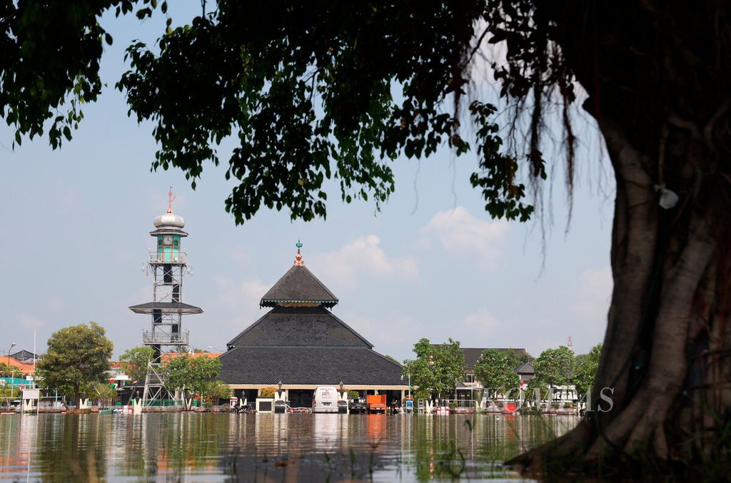 Banjir yang menggenangi alun-alun dengan latar belakang bangunan Masjid Agung Demak di Kabupaten Demak, Jawa Tengah, Rabu (20/3/2024). Banjir juga menghentikan aktivitas warga dan terganggungnya perekonomian di kawasan Kota Demak. 
