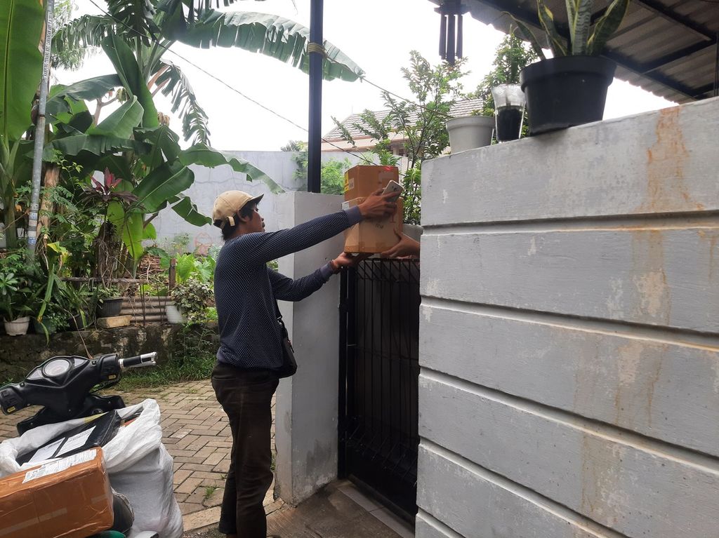 Seorang warga menerima paket dari kurir ekspedisi, Damiri (42), di kawasan Kelurahan Gaga, Tangerang, Banten, Kamis (9/3/2023).