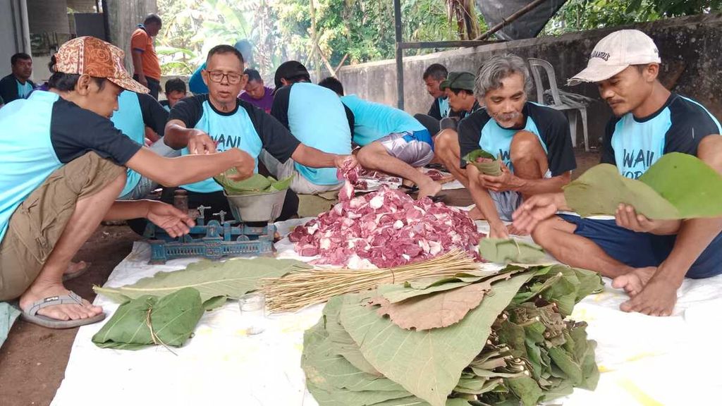 Jemaah Mushala Mutmainah di Desa Kracak, Ajibarang, Banyumas, Jawa Tengah, mengemas daging kurban dengan memakai daun jati untuk mengurangi sampah plastik, Kamis (29/6/2023).