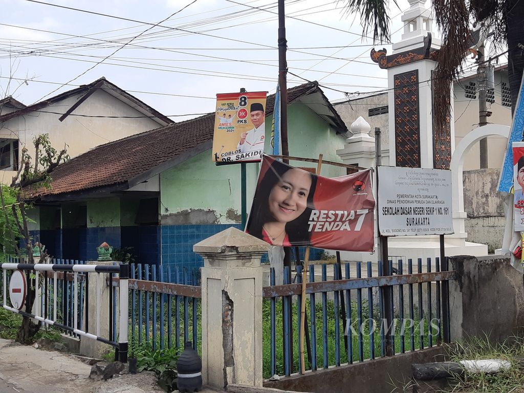 Baliho caleg dipasang berdampingan dengan papan informasi salah satu sekolah dasar di wilayah Kecamatan Banjarsari, Surakarta, Jawa Tengah, pada Sabtu (30/12/2023). Baliho caleg di masa kampanye Pemilihan Umum 2024 menjamur di beragam tempat publik.