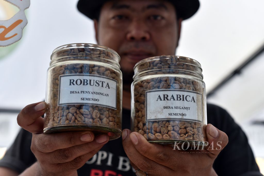 Pedagang kopi asal Semendo, Kabupaten Muara Enim, menunjukkan produk mereka di sela acara ”Morning Coffee dan Launching Kopi Sumsel” di Palembang, Sumatera Selatan, Minggu (12/5/2024).