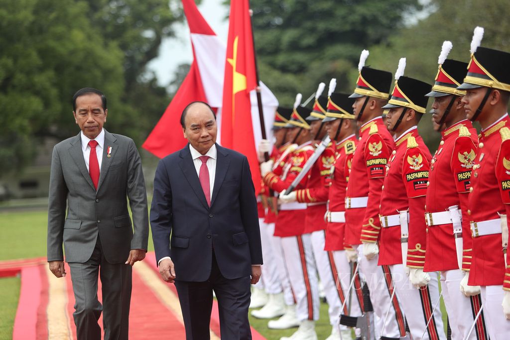 Presiden Joko Widodo bersama Presiden Vietnam Nguyen Xuan Phuc berjalan bersama dalam upacara penyambutan di Istana Kepresidenan, Bogor, Jawa Barat, Kamis (22/12/2022). 