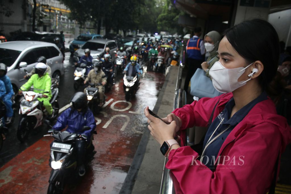 Calon penumpang bus Transjakarta menunggu kedatangan bus di Halte Pasar Palmerah, Jakarta, Selasa (21/2/2023). 