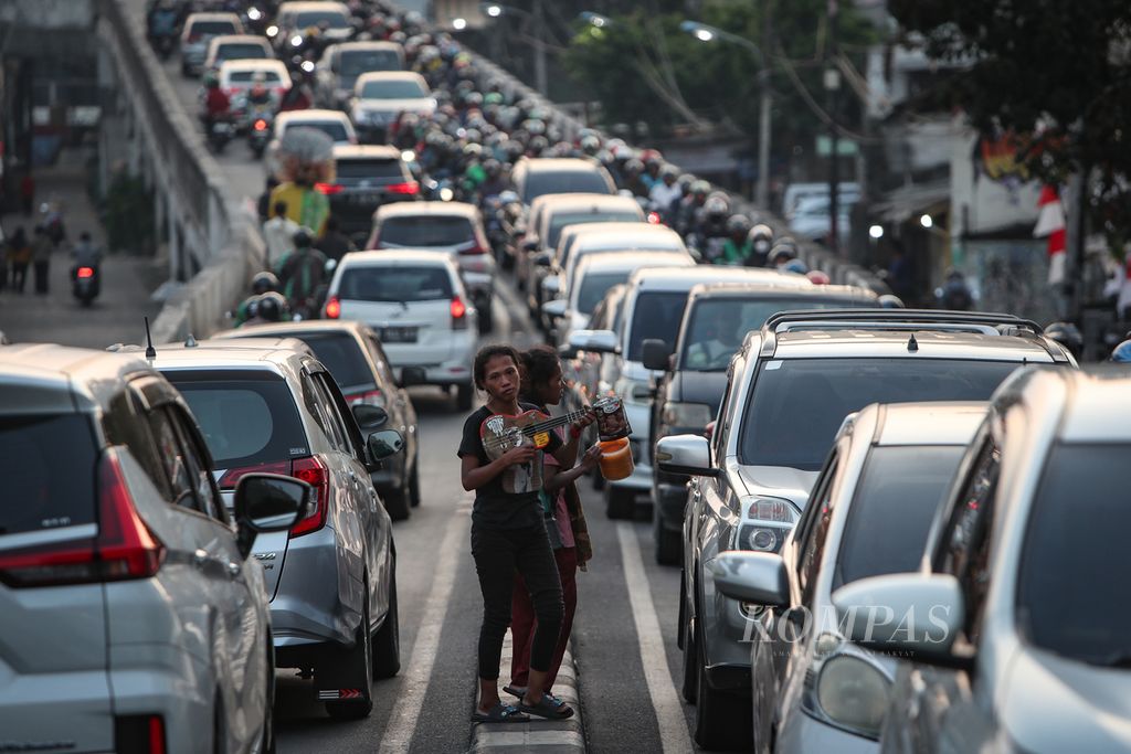Pengamen berjalan di antara antrean kendaraan di Jalan Raya Kalibata, Pancoran, Jakarta Selatan, Rabu (9/8/2023). Sektor transportasi menjadi salah satu penyumbang polusi udara di Jakarta. 
