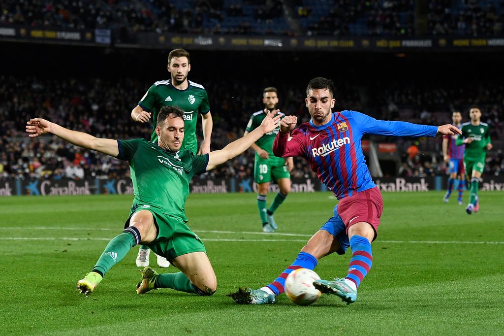 Bek Osasuna, Unai Garcia (kiri), berusaha menghentikan laju penyerang Barcelona, Ferran Torres, dalam lanjutan Liga Spanyol di Stadion Camp Nou, Barcelona, Spanyol, Senin (14/3/2022) dini hari WIB. Barcelona menang telak 4-0.