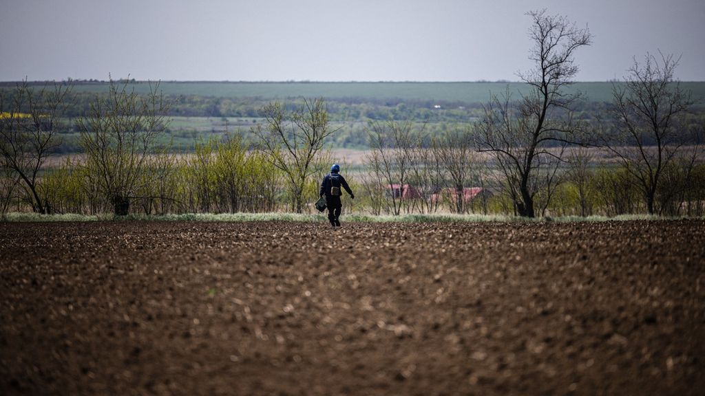 A member of a demining team of the State Emergency Service of Ukraine rolls out a wire during the preparations to destroy an unexploded missile remaining near the village of Hryhorivka, Zaporizhzhia Region, on May 5, 2022, amid the Russian invasion of Ukraine. It's planting season in Ukraine and in addition to a spiking need for fuel and fertilizer, demining teams are flooded with calls to destroy the unexploded missiles or mines in fields, which in some places have wounded or killed farmers. 