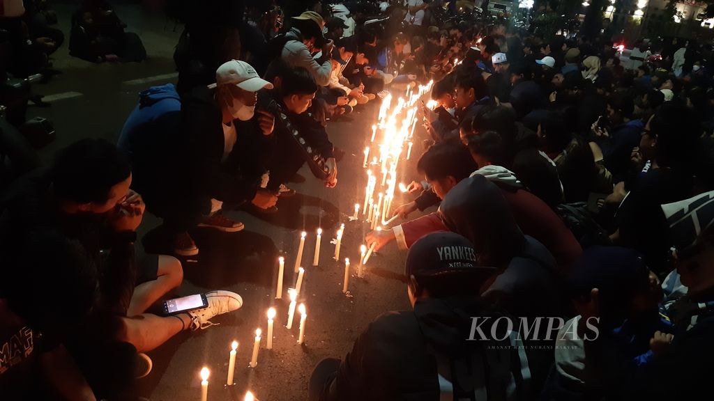 Puluhan Aremania menggelar doa bersama di sisi timur Stadion Gajayana Malang, Jawa Timur, Minggu (2/10/2022) malam. Selain mengirim doa untuk rekan-rekannya yang telah meninggal dalam Tragedi Kanjuruhan, mereka juga berharap kasus diusut tuntas dan yang bertanggung jawab atas insiden tersebut agar ditindak.