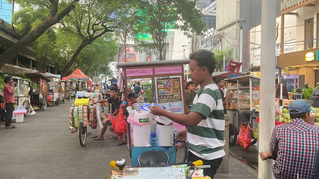 Pedagang kopi keliling sedang berjualan di sekitar Stasiun Sudirman, Jakarta Pusat, Kamis (2/5/2024).