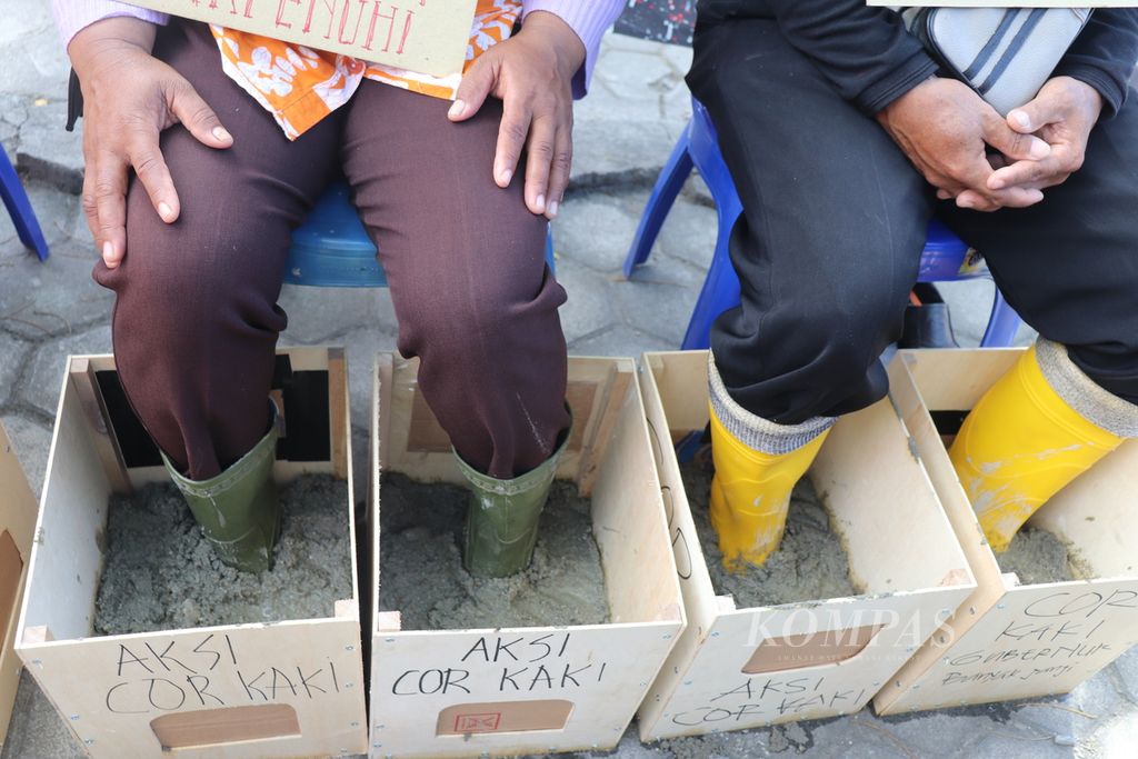 Tampak kaki dua petani dari Kabupaten Poso, Sulawesi Tengah, dicor atau dibeton dalam unjuk rasa mereka di Palu, Sulteng, Selasa (24/5/2022). Pengecoran merupakan bentuk protes dan tuntutan terhadap pembayaran kompensasi atas sawah dan kebun mereka yang terendam PLTA Poso I.
