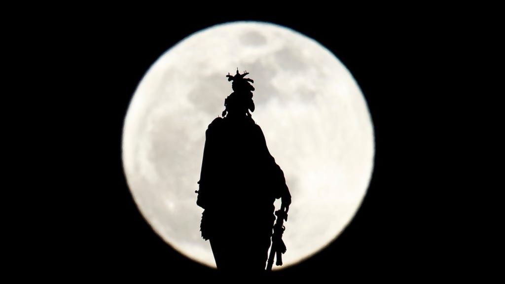 Siluet patung kebebasan yang berada di puncak kubah US Capitol di Washington DC, Amerika Serikat, dengan latar belakang gerhana bulan istimewa <i>super blood wolf moon</i>, Minggu (20/1/2019).