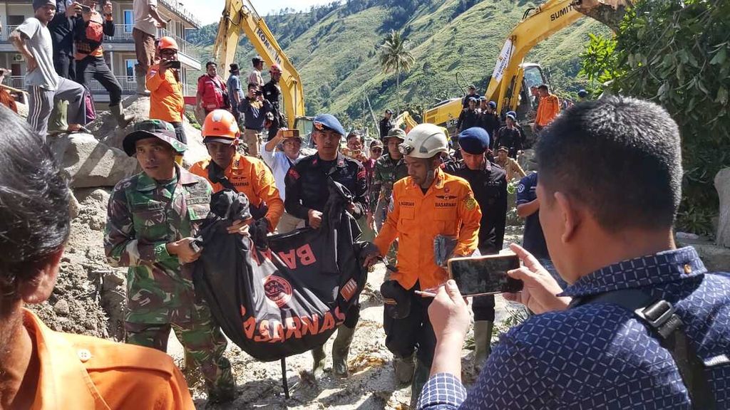Tim pencarian dan pertolongan (SAR) gabungan mengevakuasi korban meninggal yang ditemukan di bawah batuan besar yang terbawa banjir bandang di Desa Simangulampe, Kecamatan Baktiraja, Kabupaten Humbang Hasundutan, Sumatera Utara, Senin (4/12/2023).