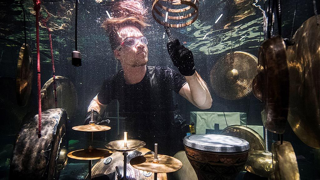Anggota band  Between Music dalam foto yang diambil, Rabu (19/4), tampil di dalam akuarium kaca penuh dengan air dan memainkan alat musik yang dirancang khusus untuk pertunjukan musik di dalam air saat geladi bersih menjelang konser di dalam air AquaSonic di Aarhus, Denmark.