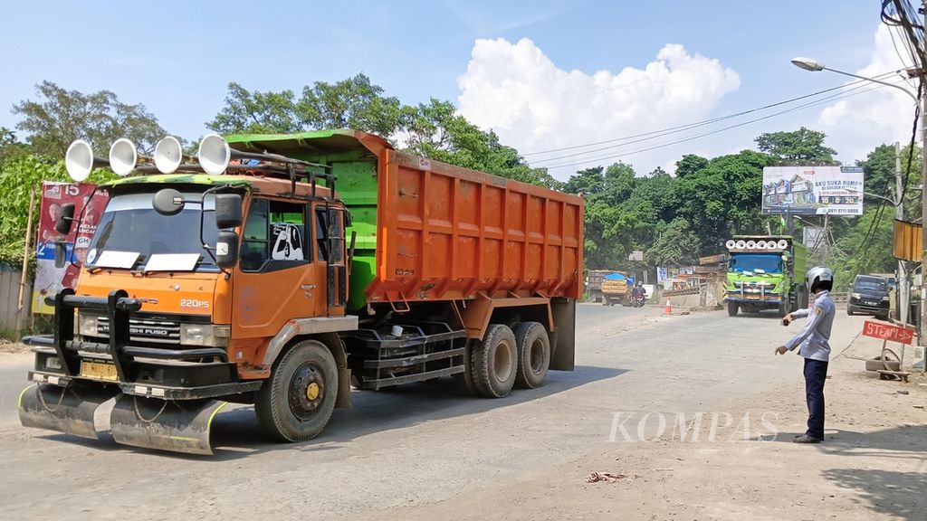 Petugas Dinas Perhubungan Kabupaten Bogor sedang mengawasi arus lalu lintas di Parung Panjang, Kabupaten Bogor, Selasa (12/12/2023). Pembatasan jam operasional truk tidak bermuatan pada pukul 13.00-16.00 banyak dilarang oleh para sopir truk.