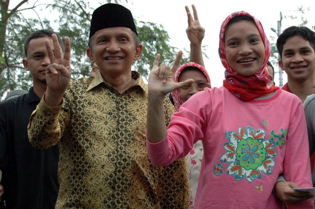 Presidential candidate Amien Rais and his family wave and sing as they walk together to the polling place (TPS) 132 near his residence in Pandeansari Hamlet, Condongcatur Village, Sleman Regency, DI Yogyakarta, Monday (5/7/2004). In Amien's opinion, the election is now running smoothly and transparently so that he is optimistic that he can advance to the second round in September.