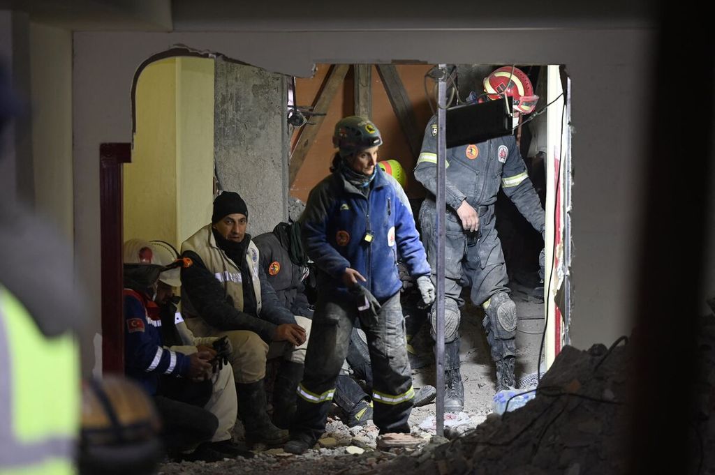  Anggota tim penyelamat mencari korban gempa yang terperangkap dalam reruntuhan gedung yang ambruk di Kahramanmaras, Turki, Senin (13/2/2023).  