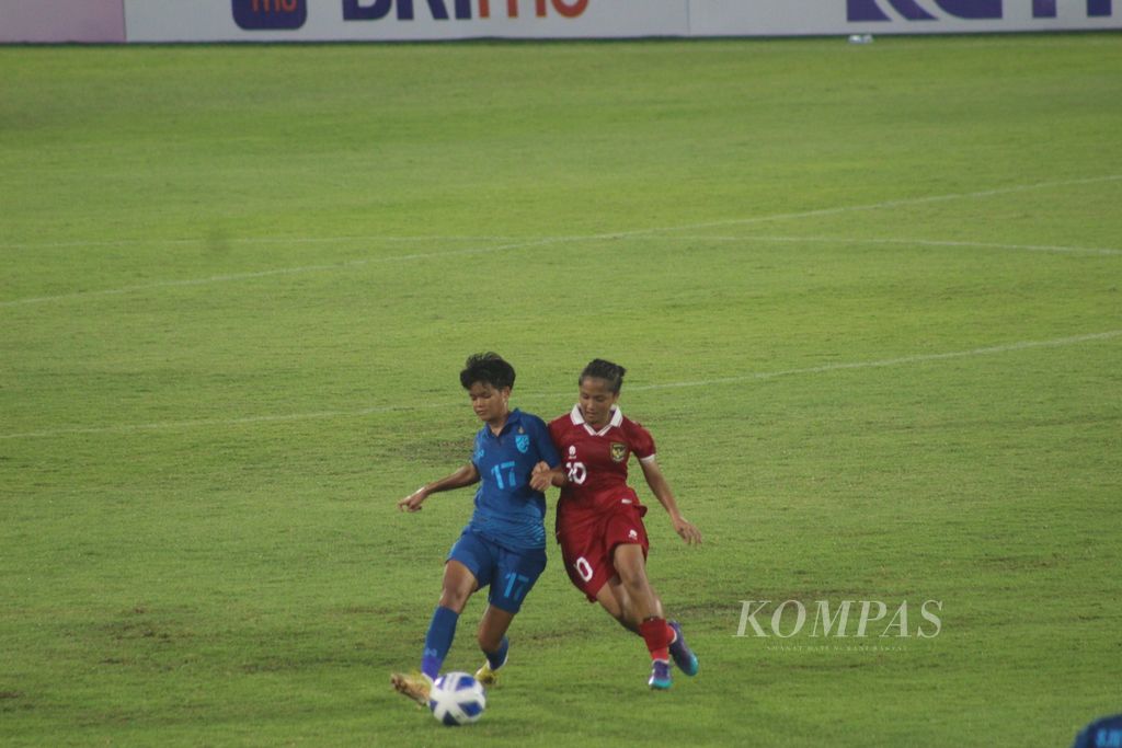 Pemain Thailand, Nualanong Muensri (biru), berebut bola dengan pemain timnas Indonesia, Sheva Imut Furyzcha, dalam pertandingan Semifinal Sepak Bola Putri AFF 2023 di Stadion Gelora Sriwijaya Jakabaring, Palembang, Sumatera Selatan, Kamis (13/7/2023). Dalam pertandingan tersebut, Indonesia kalah telak 1-7 dari Thailand. 
