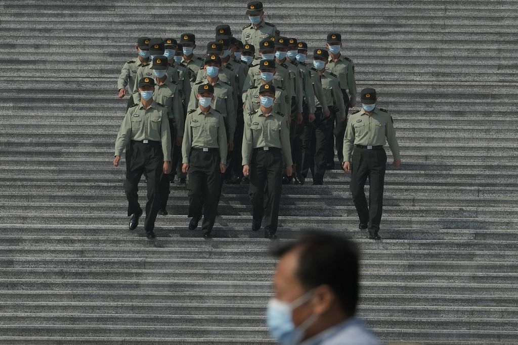 Anggota militer China berjalan menuruni tangga di depan Balai Agung Rakyat di Beijing pada Selasa (27/9/2022).