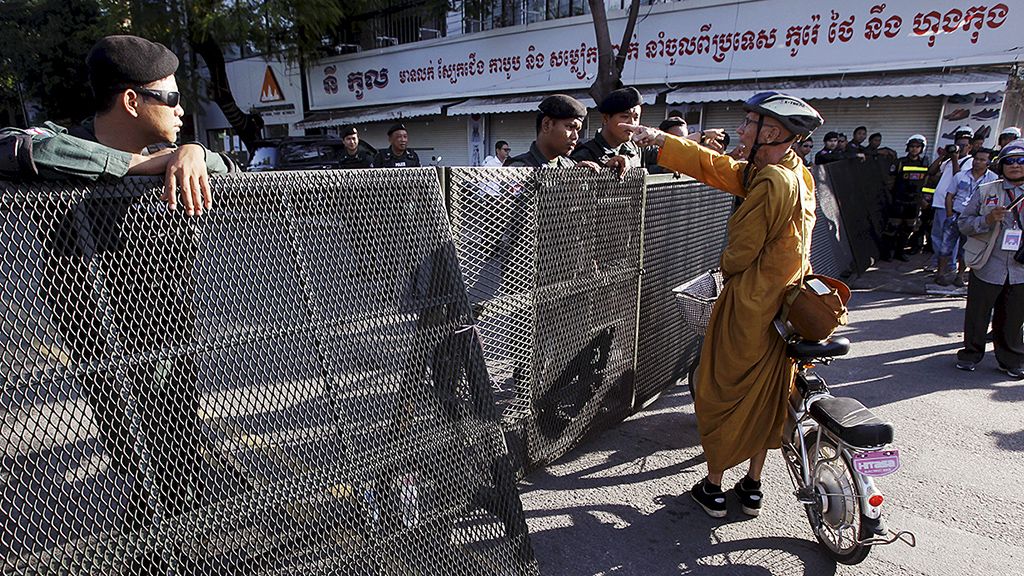 Seorang pendeta Buddha  meminta diperbolehkan melintasi jalan yang ditutup di luar gedung Mahkamah Agung di Phnom Penh, Kamboja, Kamis (16/11).  Mahkamah Agung negara itu membubarkan Partai Penyelamat Nasional Kamboja (CNRP) yang merupakan partai oposisi.