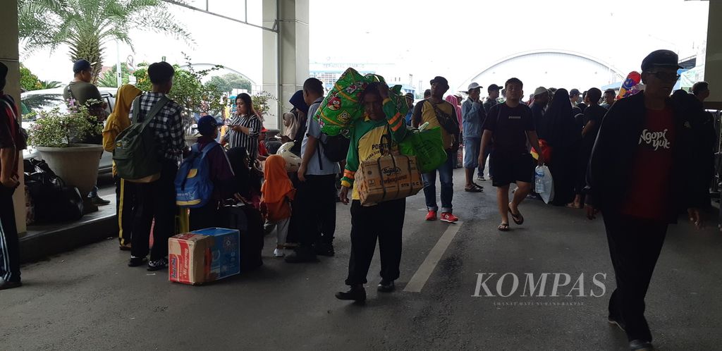 Kuli angkut di Gapura Surya Tanjung Perak, Surabaya, membantu membawakan barang milik penumpang Kapal Motor Labobar, Rabu (8/3/2023). Mereka menerima upah Rp 200.000 hingga Rp 250.000 per penumpang.