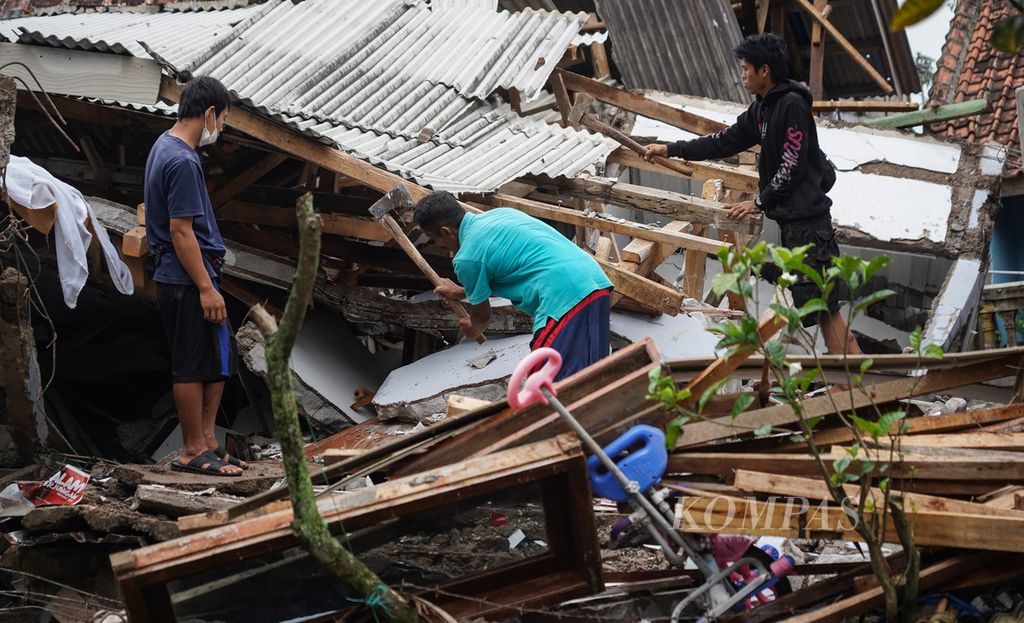 Warga Kampung Rawacina, Nagrak, Kecamatan Cianjur, Kabupaten Cianjur, Jawa Barat, mencari benda-benda yang bisa diselamatkan di antara timbunan runtuhan rumahnya akibat gempa, Rabu (23/11/2022). 