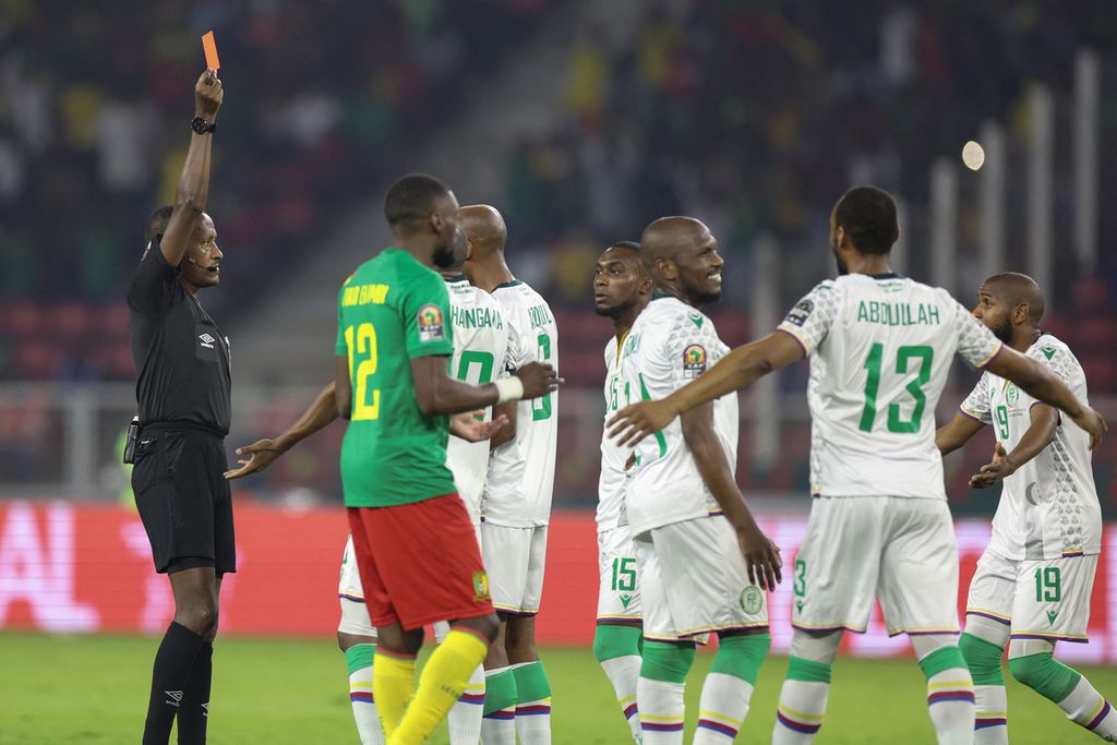 Wasil asal Etiopia, Bamlak Tessema, memberikan kartu merah kepada kapten Komoro, Nadjim Abdou (keempat dari kiri), pada laga babak 16 besar Piala Afrika 2021 melawan Kamerun, Selasa (25/2/2022) dini hari WIB, di Stadion Stadion Paul Biya, Kamerun. Kondisi itu membuat Komoro bermain selama lebih dari 83 menit dengan 10 pemain.