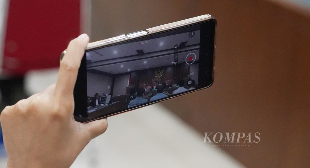 Seorang jurnalis merekam suasana saat digelar sidang pertama dengan agenda pembacaan dakwaan atas kasus perubahan data oleh Panitia Pemilihan Luar Negeri (PPLN) di Kuala Lumpur Malaysia di Pengadilan Negeri Jakarta Pusat, Jakarta, Rabu (13/3/2024). 