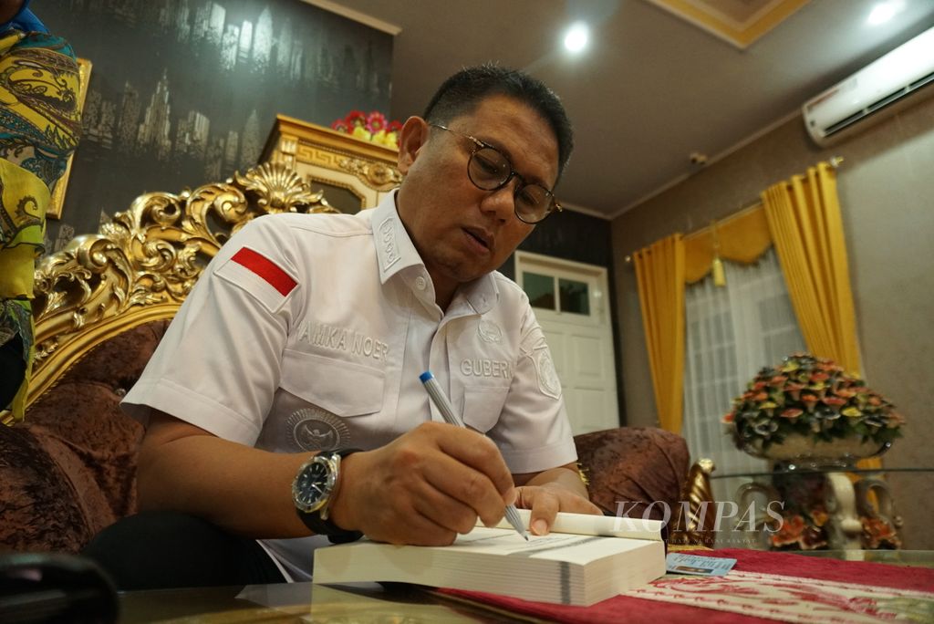 Penjabat Gubernur Gorontalo Hamka Hendra Noer menandatangani buku karyanya yang berjudul <i>Ketidakjujuran Birokrasi Indonesia</i> ketika ditemui di rumah dinasnya di Kota Gorontalo, Provinsi Gorontalo, Sabtu (3/12/2022).