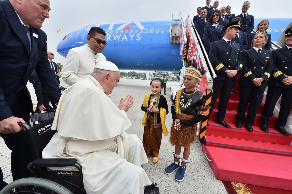 Paus Fransiskus menerima karangan bunga yang diberikan dua anak-anak berpakaian tradisional, di Bandara Internasional Soekarno-Hatta, Tangerang, Banten, Selasa (3/9/2024). 