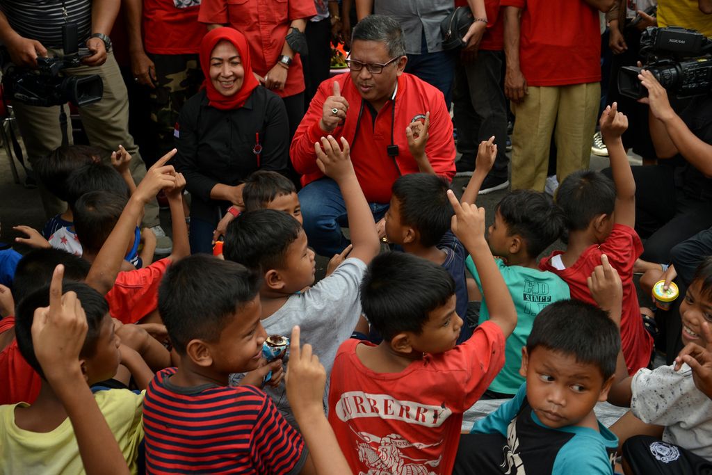 Sejumlah anak mengacungkan jarinya saat ditanya Sekretaris Jenderal PDI-P Hasto Kristiyanto di Jalan Baladewa, Johar Baru, Jakarta Pusat, Minggu (8/1/2023). Acara untuk menyambut HUT Ke-50 Partai Demokrasi Indonesia Perjuangan (PDI-P) ini membagikan makanan kepada ribuan warga. 