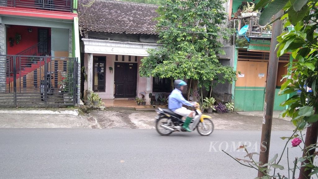 Seorang warga tengah melintas di depan rumah milik Nurhasan di Dusun Botosari, Desa Dukuh Mencek, Kecamatan Sukorambi, Kabupaten Jember, Jawa Timur, Senin (14/2/2022) siang. Nurhasan merupakan pimpinan padepokan Tunggal Jati Nusantara.