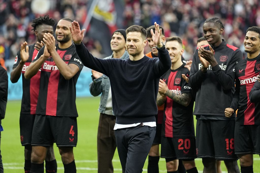 Pelatih Bayer Leverkusen Xabi Alonso dan para pemainnya merayakan kemenangan setelah pertandingan Liga Jerman antara Bayer Leverkusen dan Hoffenheim di Stadion BayArena, Leverkusen, Jerman, Sabtu (30/3/2024). Leverkusen menang 2-1. 