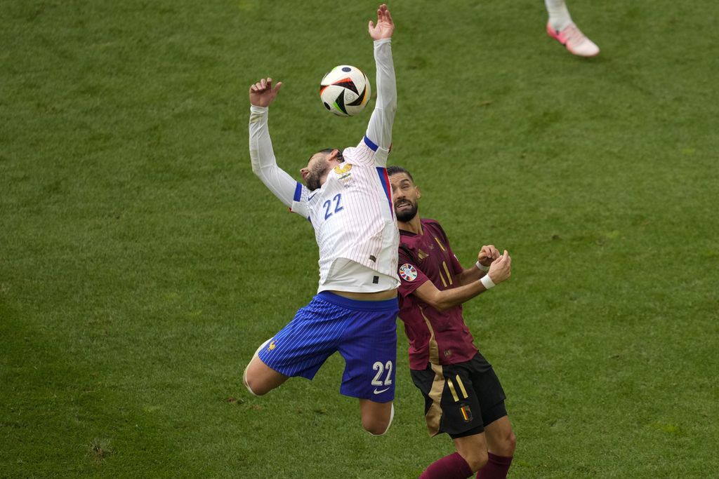 Pemain Perancis, Theo Hernandez, menyundul bola di depan pemain Belgia, Yannick Carrasco, dalam pertandingan babak 16 besar Piala Eropa 2024 antara Perancis dan Belgia di Stadion Duesseldorf Arena, Jerman, Senin (1/7/2024). 