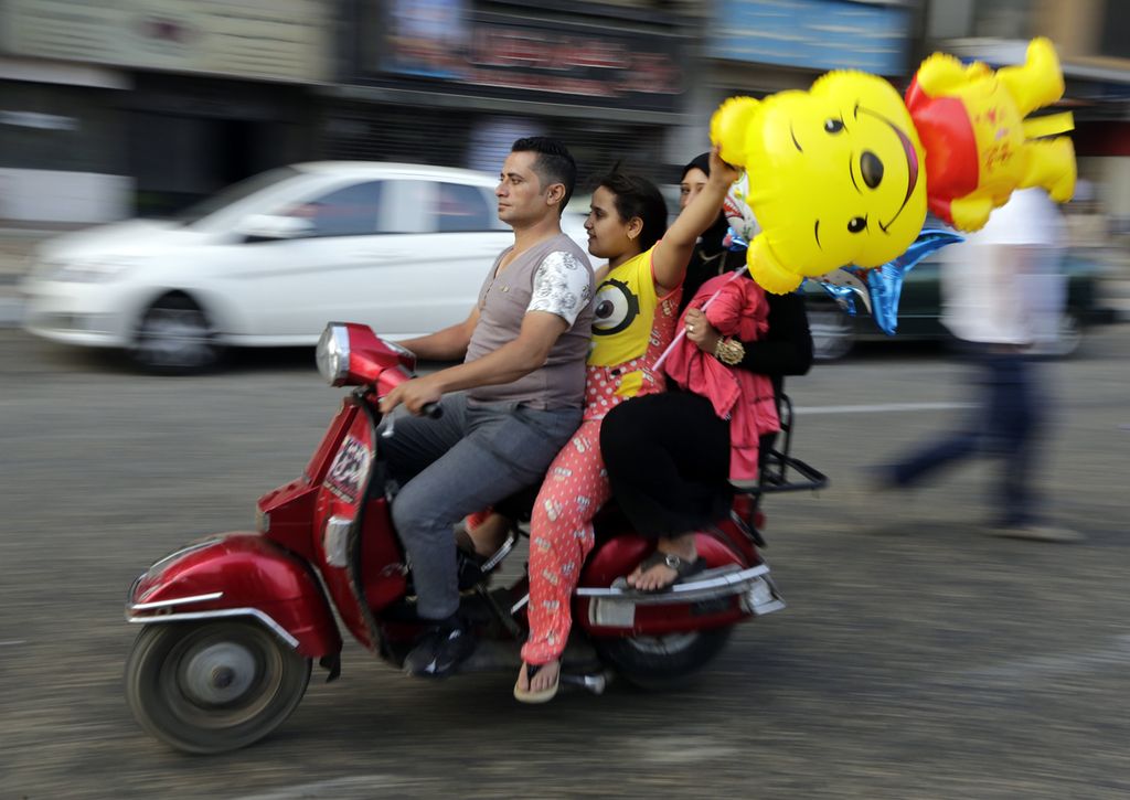 Warga mengendarai sepeda motor saat merayakan Idul Fitri di Kairo, Mesir, 17 Juli 2015. 