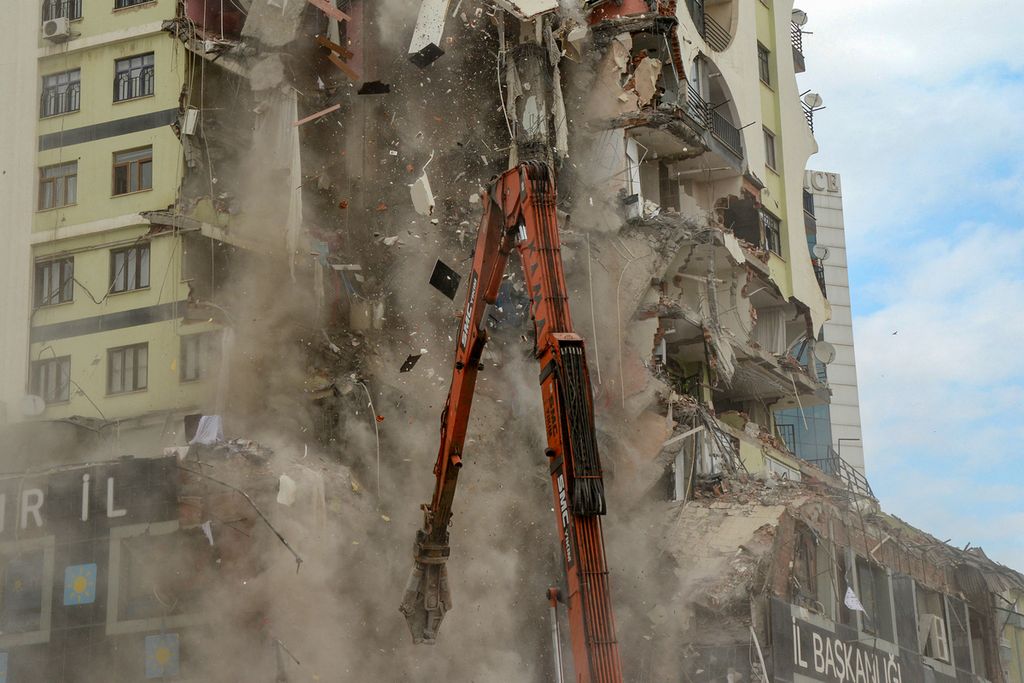 Foto yang diambil pada Rabu (22/2/2023) memperlihatkan alat berat tengah membantu proses penghancuran sebuah apartemen yang rusak akibat gempa di Diyarbarkir, Turki. Pemerintah Turki segera memulai proses rehabilitasi dan rekonstruksi pascagempa. 