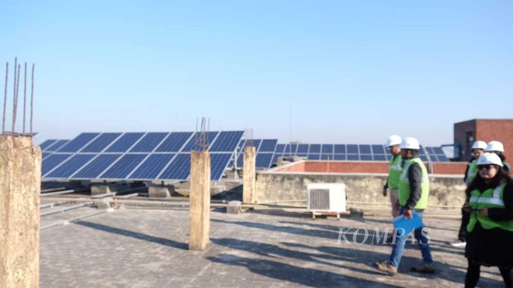 Petugas memeriksa kelancaran proses konversi energi melalui panel surya di atap kampus Universitas Jawaharlal Nehru di New Delhi, India, Rabu (14/12/2022). Kegiatan memantau panel surya di atap gedung kampus ini salah satu bagian dari kunjungan kerja tim Indika Energy di India.