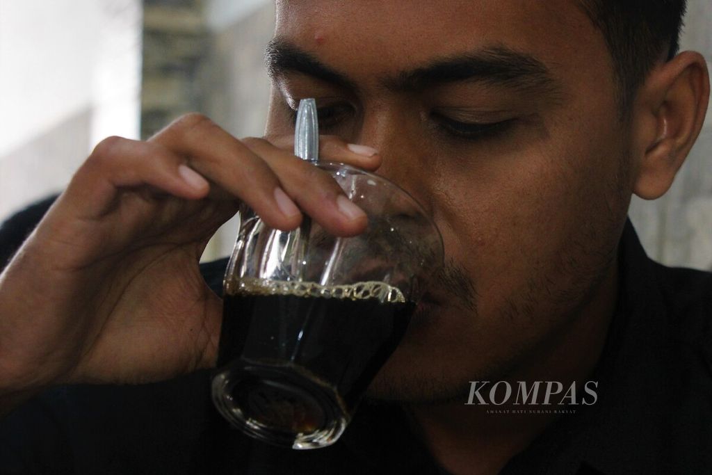 Seorang pengunjung menyeruput kopi saring di warung kopi Solong Pango, di Kota Banda Aceh, Provinsi Aceh, Selasa (28/2/2023). Budaya ngopi masih mengakar di kalangan warga Aceh. Kondisi ini mendorong pertumbuhan warung kopi semakin banyak.