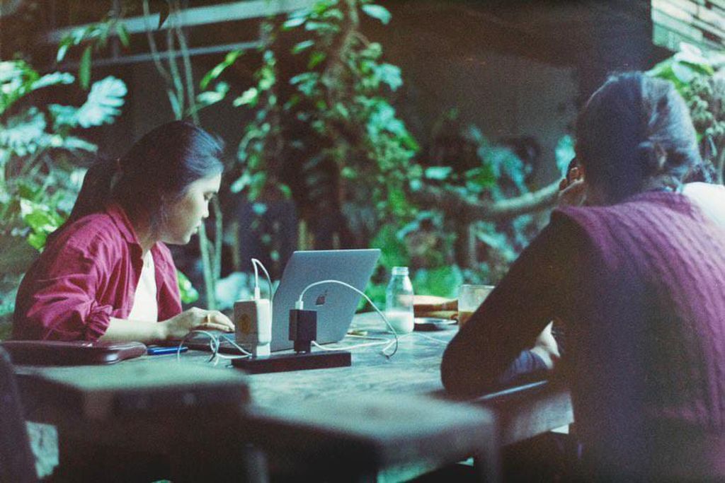 Dua mahasiswa mengerjakan tugas di sebuah kafe di Kota Malang.