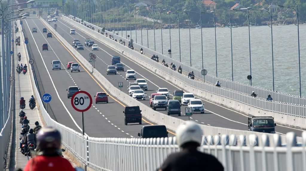 Arus lalu lintas dari Pulau Madura ke Surabaya (kanan) terlihat padat di Jembatan Suramadu, Kabupaten Bangkalan, Jawa Timur, pertengahan 2021.